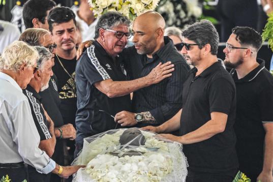 El exjugador del Santos Manoel Maria (izquierda) abraza al hijo de Pelé, Edinho