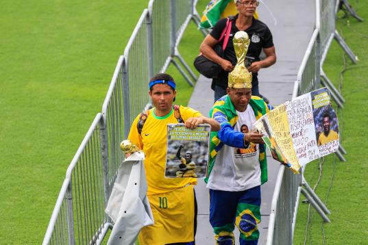 Seguidores despiden al delantero brasileño Pelé con pancartas
