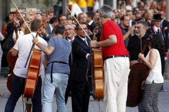 Artur Mas y el alcalde de Barcelona, Xavier Trias, saludan a los violonchelistas que han participado en la ofrenda floral.