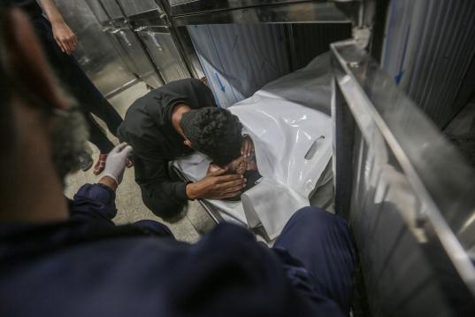 Un joven palestino llora a su pariente, que murió en un ataque aéreo israelí dentro de la morgue del hospital Al-Shifa.