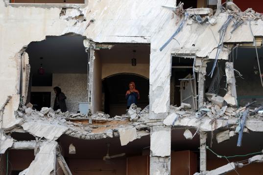 Dos mujeres miran lo que queda entre los escombros de su casa en Gaza. 