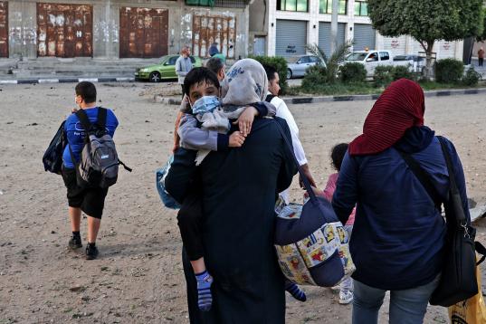 Las familias palestinas se dirigen a las oficinas de la ONU en la ciudad de Gaza por seguridad después del ataque a varios edificios.