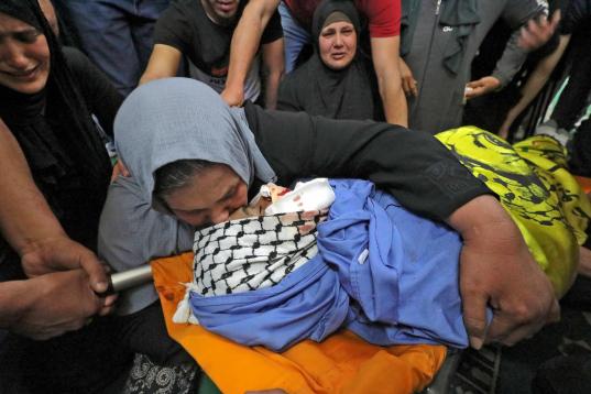 La madre del palestino Hussein al-Titi, de 26 años, asesinado por disparos israelíes en el campo de refugiados de Fawwar, cerca de la ciudad de Hebrón, en la ocupada Cisjordania, llora su cuerpo