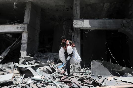 Un palestino camina sobre los escombros de la torre Al-Jawhara en la ciudad de Gaza