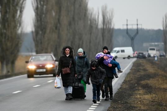 Una familia de refugiados ucranianos camina por la frontera entre Moldavia y Ucrania