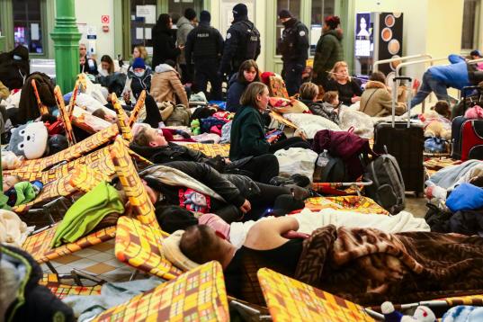 Refugiados ucranianos descansan, como pueden, en una estación de tren en Polonia