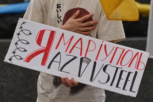 Una manifestante luce una pancarta en recuerdo de la acería Azovstal en Mariúpol