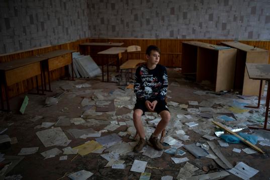 Oleksandr Morhunov, de 13 años, entre los escombros de su aula, atacada en marzo pasado, en Chernihiv. "Cuando estoy en mi clase, pienso en las ganas que tengo de que acabe la guerra". 