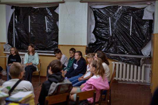 Un grupo de estudiantes, reunidos en una clase dañada por los bombardeos en el liceo Mykhailo-Kotsyubynske, este 30 de agosto, primer día de clase. 