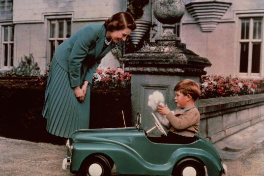 Isabel viendo a Carlos jugar con un coche en Balmoral, en septiembre de 1952.