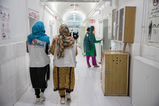 Personal de MSF camina por el pasillo en el departamento de mujeres del hospital Boost.