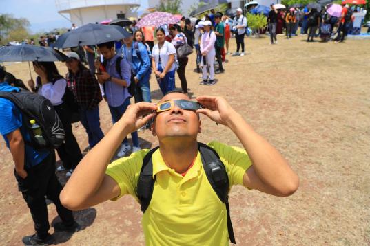Estudiantes universitarios reunidos para observar el eclipse solar en Tegucigalpa (Honduras)