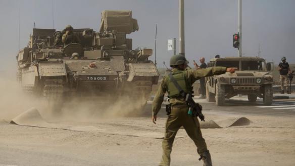 Un soldado da instrucciones a un tanque al lado de la frontera con Gaza