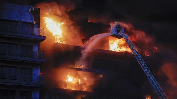 Los bomberos trabajan en la extinción del incendio en el edificio de 14 plantas en Valencia