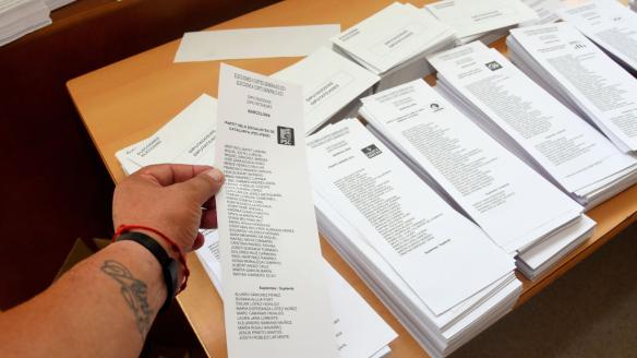 Un elector elige entre varias papeletas en un colegio electoral de Barcelona
