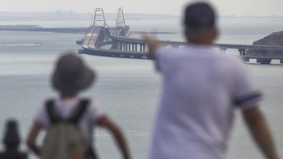 Dos personas observan desde lejos el puente de Crimea.