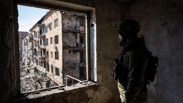 Un soldado ucraniano patrulla los edificios destruidos en la ciudad de Vuhledar