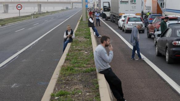 Varios conductores aguardan junto a sus vehículos en la A-3 junto al nuevo cauce del Turia durante la mañana de este miércoles.