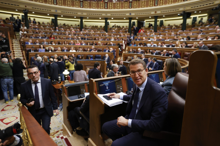 El líder popular, Alberto Núñez Feijóo, toma asiento en su escaño en el Hemiciclo de cara a la celebración del primer día del debate de investidura del líder del PSOE, Pedro Sánchez.