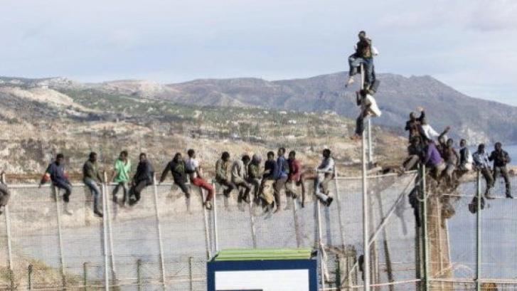 Más de una veintena de inmigrantes, encaramados durante horas en la valla de Melilla