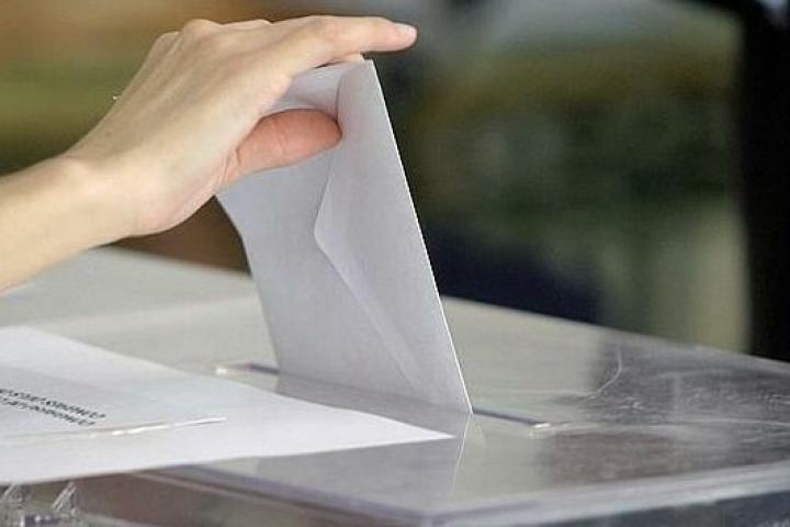 Una persona introduce su voto en una urna.