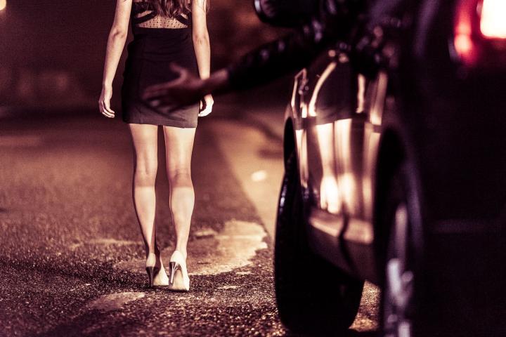 Street prostitute standing in front of the car