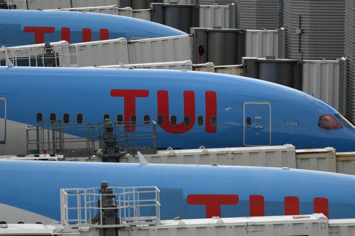 Aircraft grounded due to the COVID-19 pandemic, including planes operated by TUI are pictured on the apron at Manchester Airport in Manchester, north west England on May 1, 2020. - Irish low-cost carrier Ryanair said on Friday it planned to axe ...