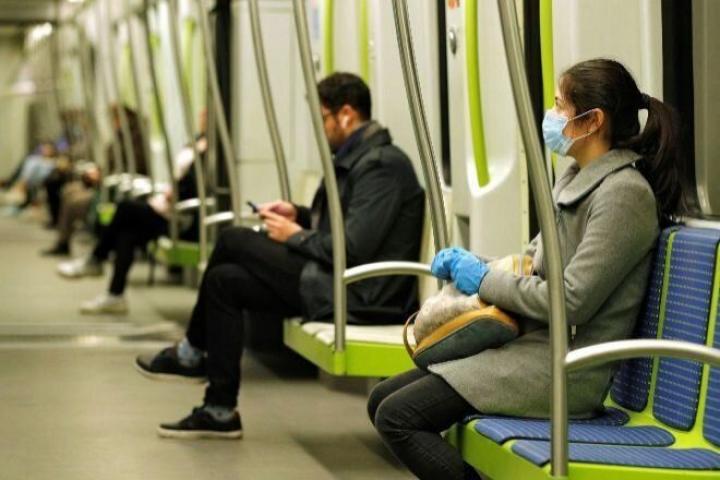 Personas viajando en transporte público con mascarilla.