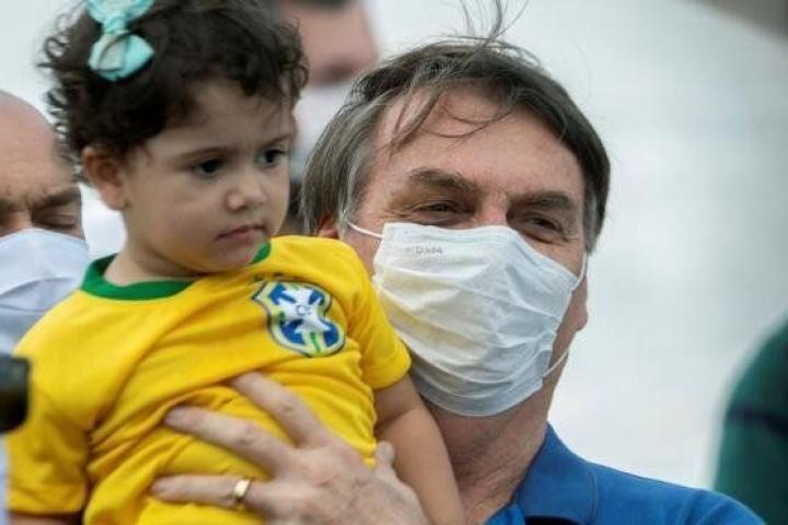 Jair Bolsonaro cogiendo en brazos a una niña, sin respetar la distancia social.