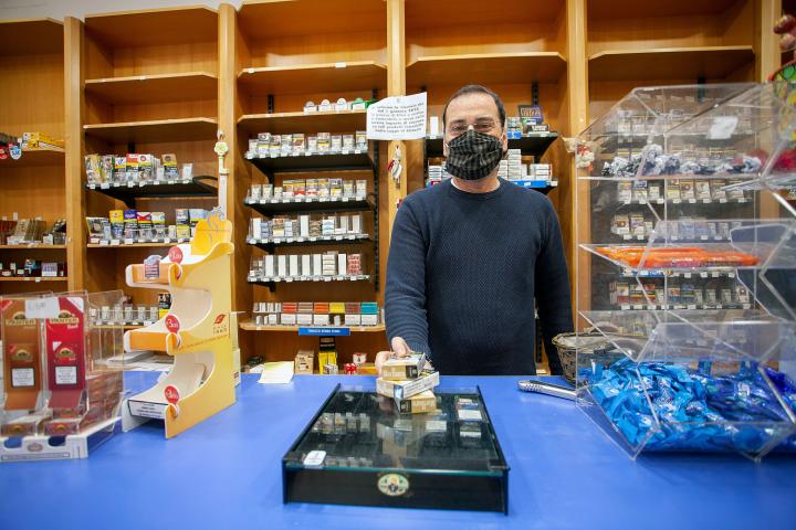 BARI, ITALY - MAY 06: Tobacco Shop's owner wears a mask on May 06, 2020 in Bari, Italy. Italy was the first country to impose a nationwide lockdown to stem the transmission of the Coronavirus (Covid-19), and its restaurants, theaters and many ot...