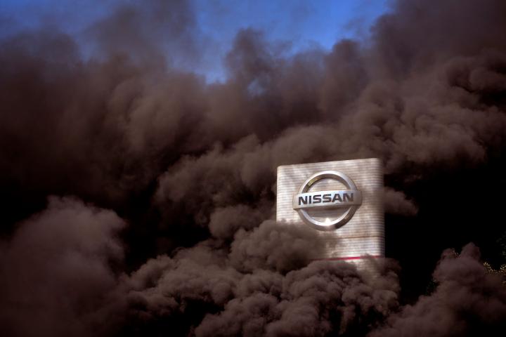 Smoke rises over the Nissan factory as workers burn tires during a protest in Barcelona, Spain, Thursday, May 28, 2020. Japanese carmaker Nissan Motor Co. has decided to close its manufacturing plans in the northeastern Catalonia region, resulti...