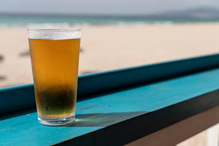 Beer glass at beach on green table
