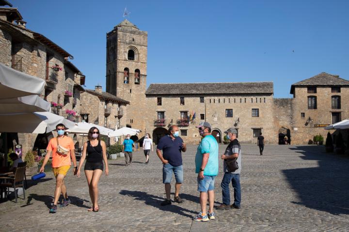 AINSA, SPAIN - JULY 19: Several tourists with masks walk through the town of Ainsa on July 19, 2020 in Ainsa, Spain. The use of masks is mandatory throughout the community of Aragon to stop the spread of the coronavirus (COVID-19). (Photo by Alv...