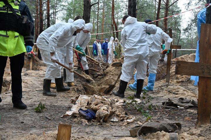 Investigadores trabajan en la fosa de Izium