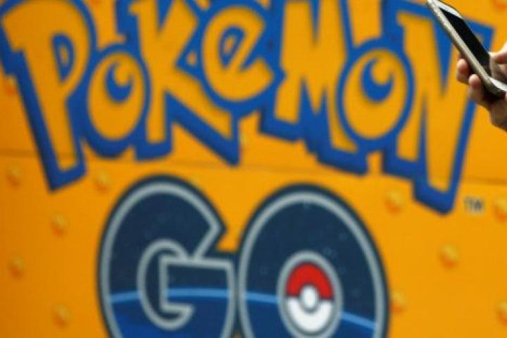 A man uses a mobile phone in front of an advertisement board bearing the image of Pokemon Go at an electronic shop in Tokyo, Japan, July 27, 2016. REUTERS/Kim Kyung-Hoon