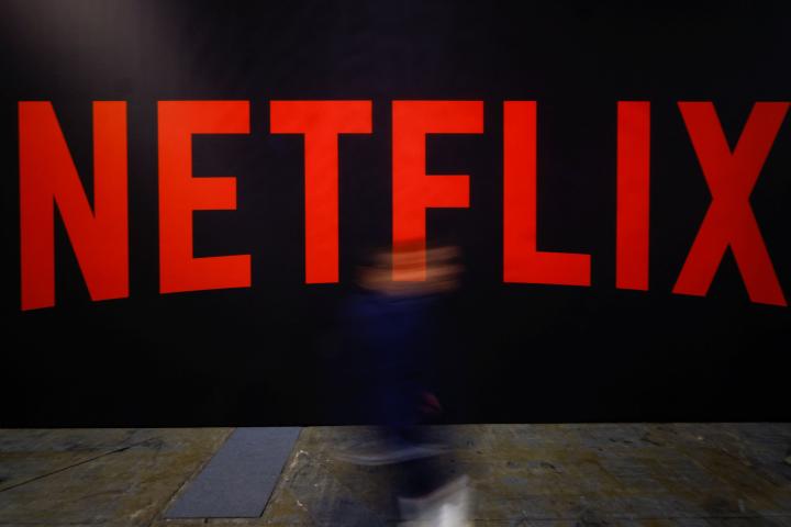 Una persona pasa por delante del logotipo de Netflix en París