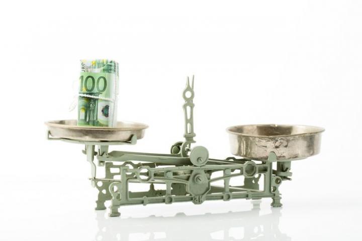 Imagen creativa con billetes de euro y una báscula