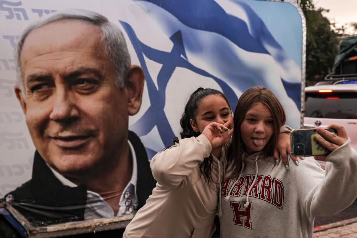 Unas chicas posan ante un autobús de campaña de Benjamín Netanyahu, el pasado 23 de octubre, en Migdal HaEmek (Israel).