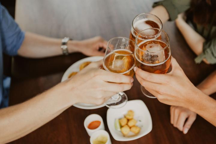 Un grupo de amigos brindando con cerveza.