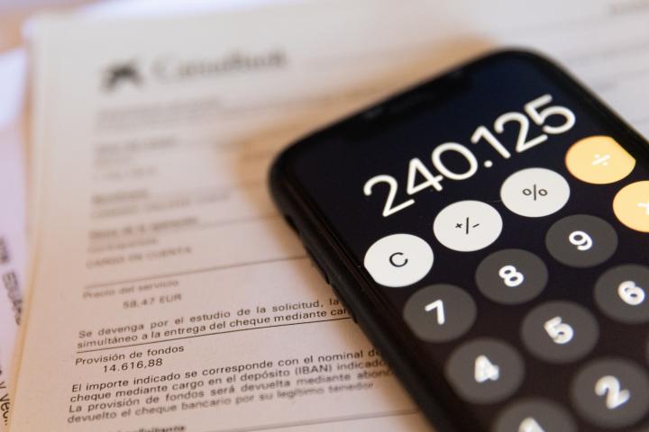 Una calculadora y una escritura de compraventa de una hipoteca