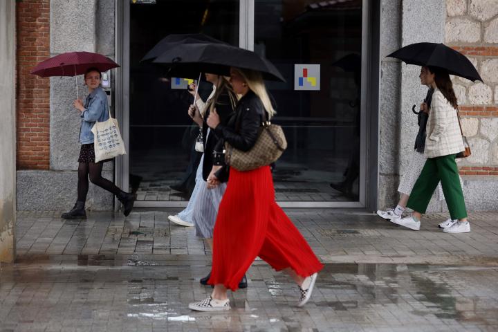 Imagen de archivo de varias personas paseando por Madrid entre la lluvia.