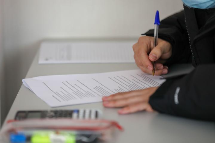 Un alumno toma apuntes en clase