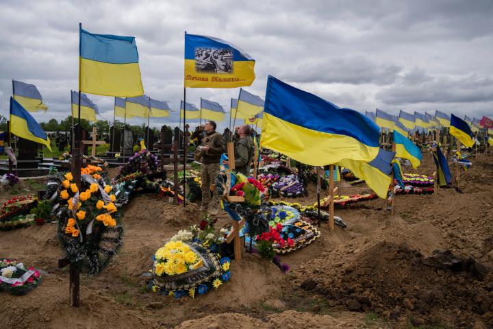 Dos soldados ucranianos beben en honor de sus compañeros caídos en el cementerio de Jarkov, en el este de Ucrania, el pasado 22 de mayo.