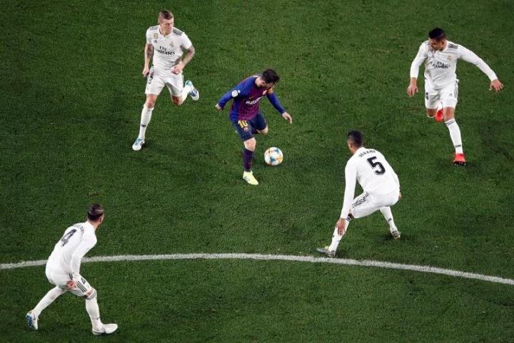 El delantero argentino del Barcelona, Leo Messi (c), controla el balón ante jugadores del Real Madrid, durante el último encuentro disputado entre ambos equipos en el Camp Nou, el 6 de febrero de 2019 en la ida de las semifinales de la Copa de...