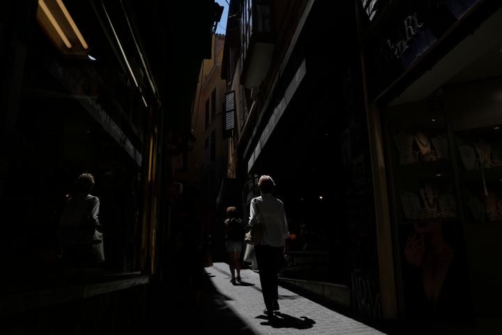 Dos mujeres pasan por una calle peatonal de tiendas en Palma de Mallorca, en plena ola de calor.