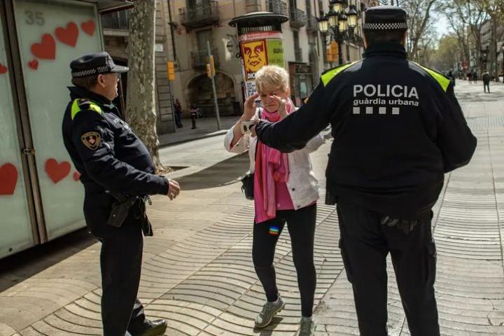 La Guardia Urbana de Barcelona para a una mujer.