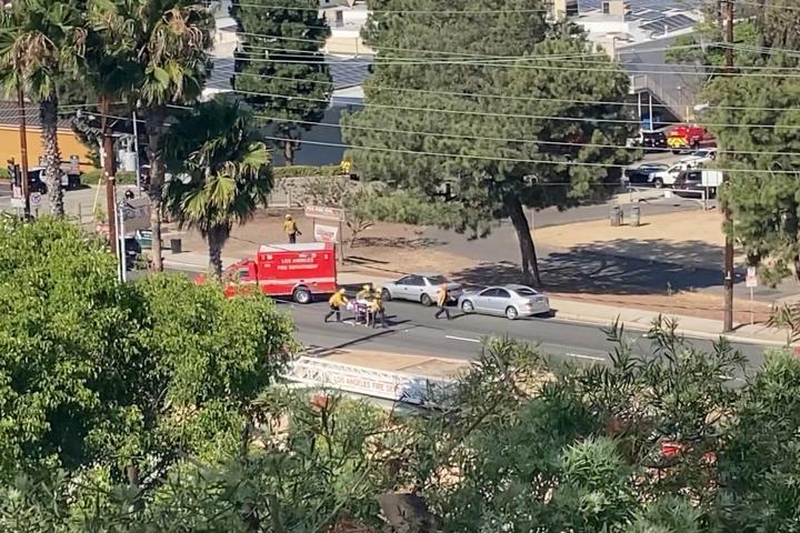 Personal de emergencia lleva una camilla tras el tiroteo en Peck Park, San Pedro, Los Ángeles.
