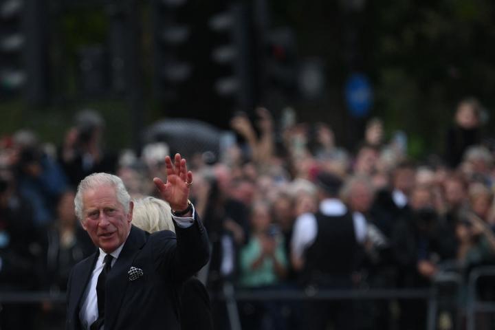 Carlos III saludando a la gente a las puertas del Palacio de Buckingham.