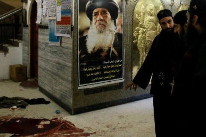 Varios religiosos coptos observan los rastros de sangre en el lugar del ataque.