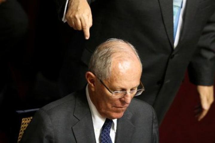 Pedro Pablo Kuczynski (sentado) mientras us abogado, Alberto Borea, se dirige al Congreso peruano.